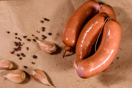 Heap of sausages, garlic and spices on brown wrapping paper. Top view