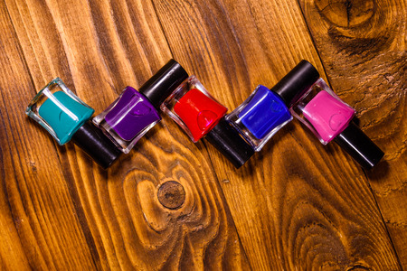 Different nail polishes on rustic wooden table. Top viewの写真素材