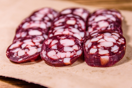 Sliced salami sausage on brown wrapping paperの写真素材