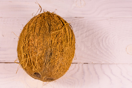 One whole coconut on white wooden table. Top viewの写真素材