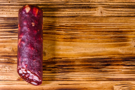 Smoked salami sausage on rustic wooden table. Top viewの写真素材