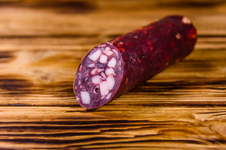 Smoked salami sausage on rustic wooden tableの写真素材