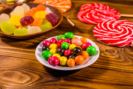 Different sweet candies on rustic wooden tableの写真素材