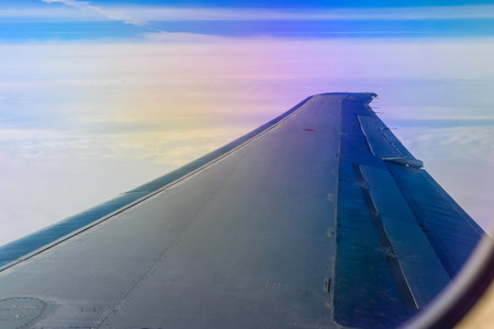 View on white clouds and wing from airplane window