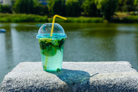 Mojito cocktail on granite parapet with river on backgroundの写真素材