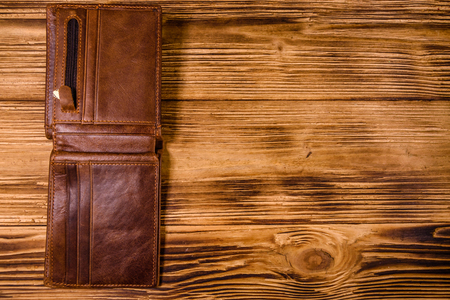 Opened brown leather wallet on rustic wooden table. Top viewの写真素材