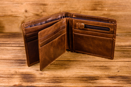Opened brown leather wallet on rustic wooden tableの写真素材