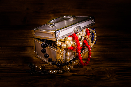 Aluminium case full of different jewelry on rustic wooden tableの写真素材