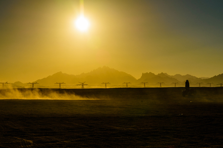 Unrecognizable man driving quad bike during safari trip at sunset in Arabian desert not far from Hurghada city, Egyptの写真素材