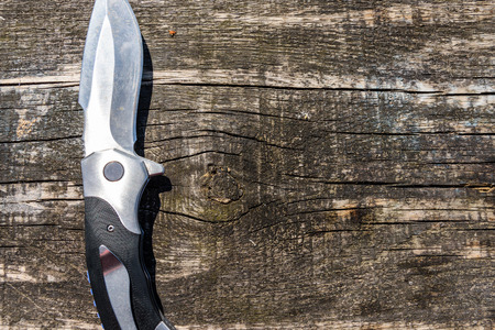 Survival folding knife on rustic wooden backgroundの写真素材