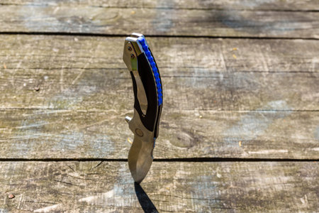 Folding knife stuck in old wooden board