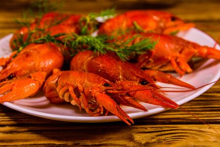 Plate with boiled crayfishes on rustic wooden tableの写真素材