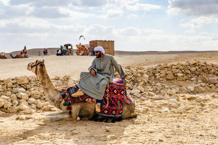Cairo, Egypt - December 8, 2018: Young bedouin riding a camel in Giza plateau. Cairo, Egyptのeditorial素材