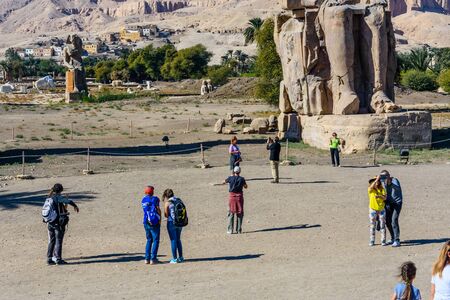 Luxor, Egypt - December 11, 2018: Tourists taking a photo of Memnon colossi (statues of Pharaoh Amenhotep III) in Luxor, Egyptのeditorial素材