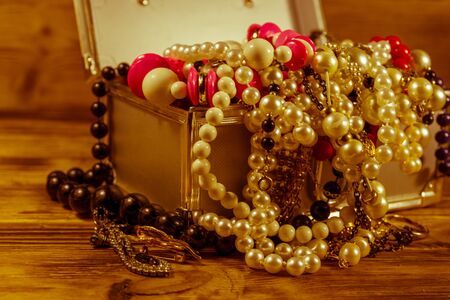 Aluminium case full of different jewelry on rustic wooden tableの写真素材