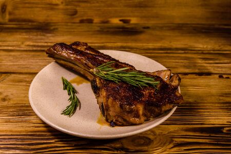 Plate with roasted ribeye steak on rustic wooden tableの写真素材