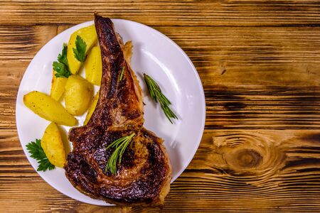 Plate with roasted ribeye steak on rustic wooden table. Top viewの写真素材