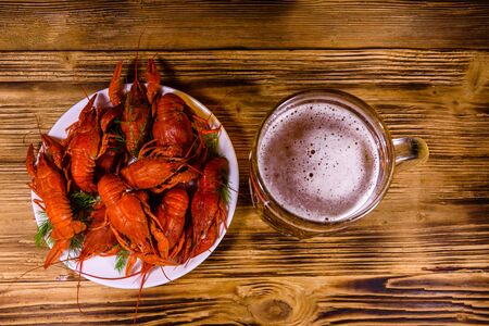 Glass of beer and boiled crayfish on rustic wooden table. Top viewの写真素材