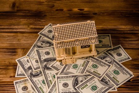 Plywood model of house and one hundred dollar banknotes. Loan, real estate conceptの写真素材