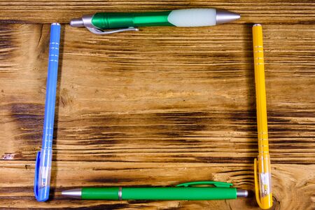 Multi colored ball pens on rustic wooden table. Top viewの写真素材