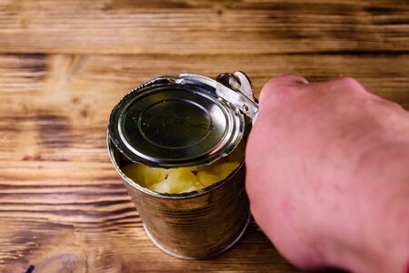 Opening of aluminium tin can with chopped canned pineappleの写真素材