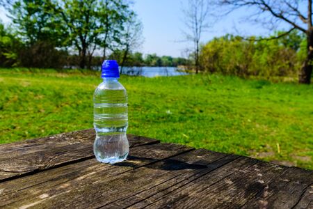 Plastic bottle with clear water on rustic wooden tableの写真素材