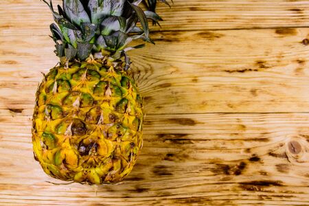 Ripe whole pineapple on rustic wooden table. Top viewの写真素材
