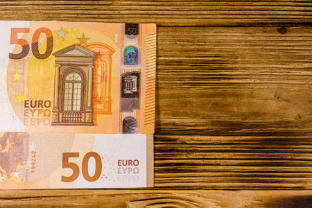 Fifty euro banknotes on rustic wooden background. Top view