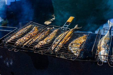 Whole scomber fish cooking in metal grate grill