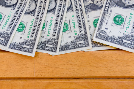 Heap of one dollar banknotes on wooden background. Top view