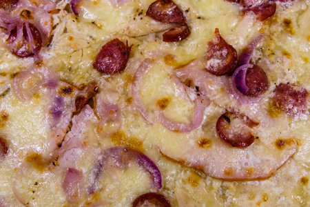 Background of pizza with sausages, ham and parmesan cheeseの写真素材