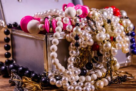 Aluminium case full of different jewelry on rustic wooden tableの写真素材