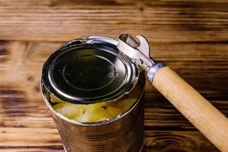Opening of aluminium tin can with chopped canned pineappleの写真素材