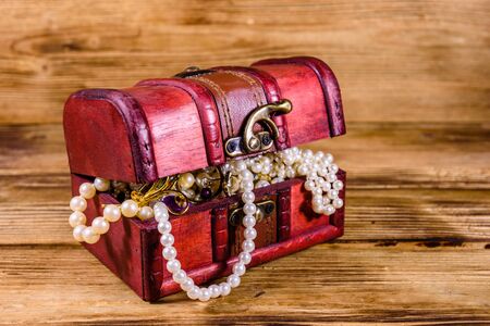 Old box of red wood full of jewelry. Treasure chestの写真素材
