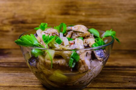 Pieces of the marinated carp fish in glass bowl on rustic wooden tableの写真素材