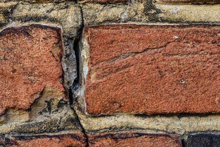 Old red brick wall with the crackの写真素材