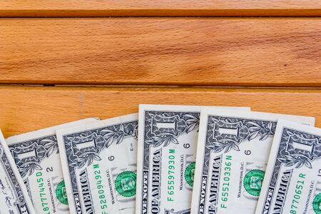 Heap of one dollar banknotes on wooden background. Top viewの写真素材
