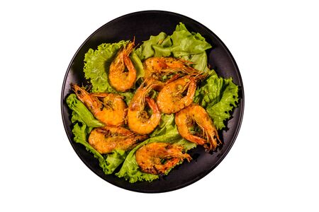Plate with grilled shrimps and lettuce leaves isolated on white backgroundの写真素材