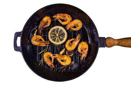 Roasted shrimps with lemon slice, garlic and rosemary in cast iron pan isolated on white backgroundの写真素材