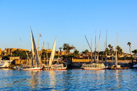 Luxor, Egypt - December 11, 2018: Traditional egyptian vessels feluccas and tourist boats moored near bank of Nile river in Luxor, Egyptのeditorial素材