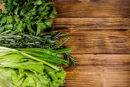 Lettuce rosemary and parsley on wooden table. Vegan food. Top viewの写真素材