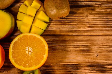 Still life with exotic fruits. Bananas, mango, oranges, grapefruit and kiwi fruits on rustic wooden table. Top viewの写真素材