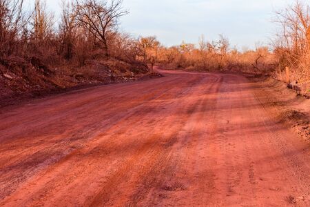 Red dirt road polluted with iron ore. Environmental pollutionの写真素材