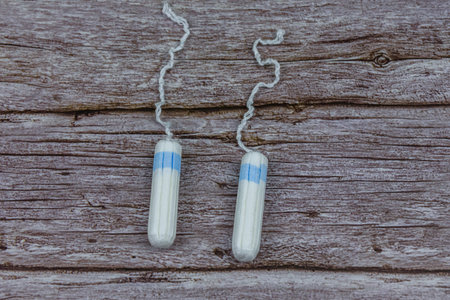 Female tampons on wooden background. Woman hygiene