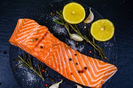 Raw fillet of salmon fish and spices on slate board. Top viewの写真素材