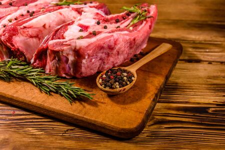Raw pork ribs with spices and rosemary on cutting boardの写真素材