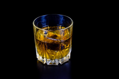 Glass of whiskey isolated on black backgroundの写真素材