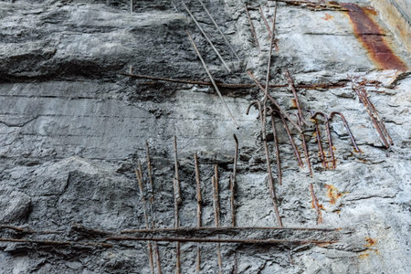 Old damaged concrete wall with rusty armature rodsの写真素材