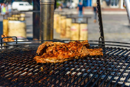 Piece of meat cooking on metal grate grillの写真素材