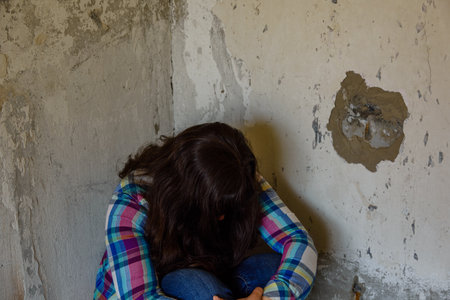 Young woman crying in abandoned house. Depression and despair conceptの写真素材